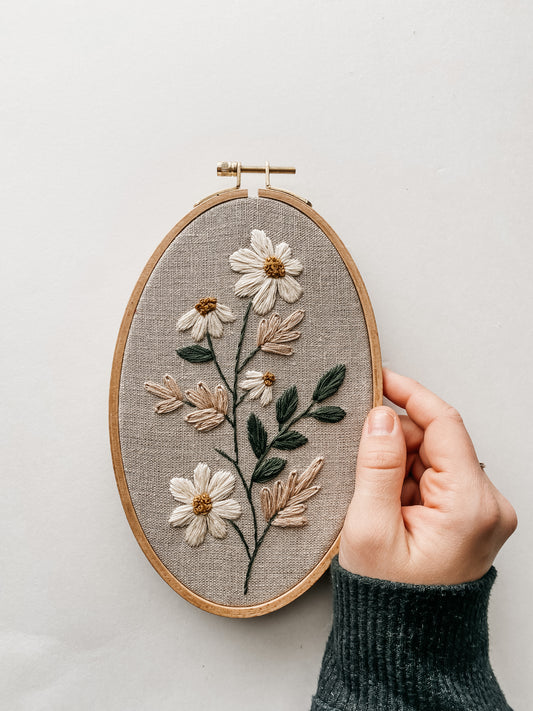 embroidered daisies, pampas grass, and leaves on linen fabric